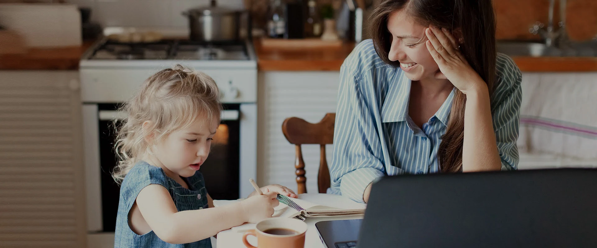 mother enjoying time with kid while on laptop