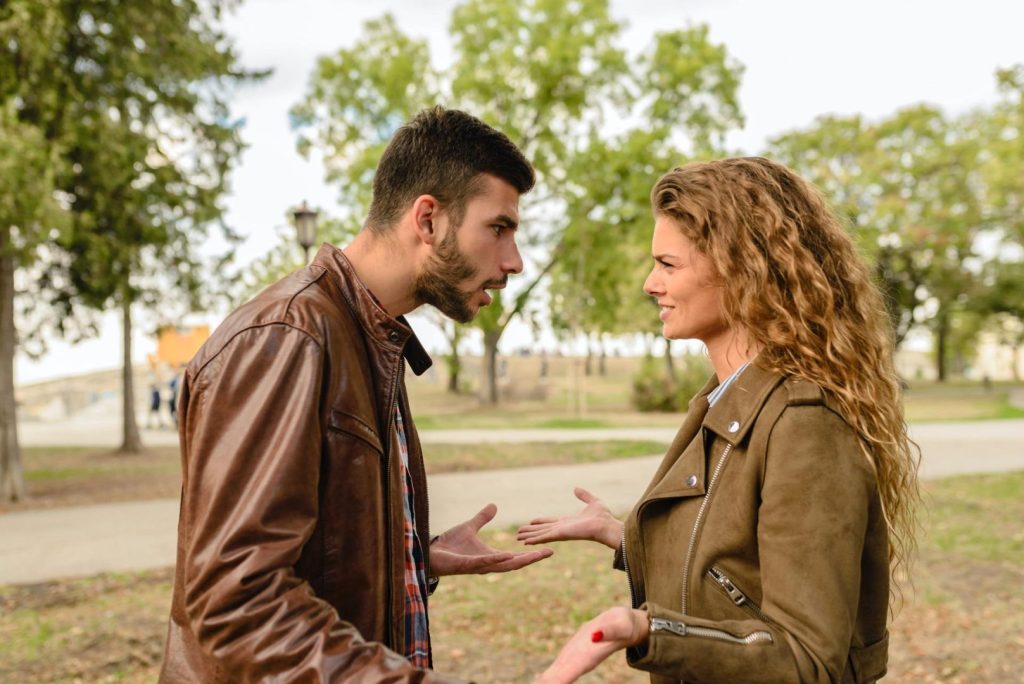 Couple in park having conversation about being cheated on