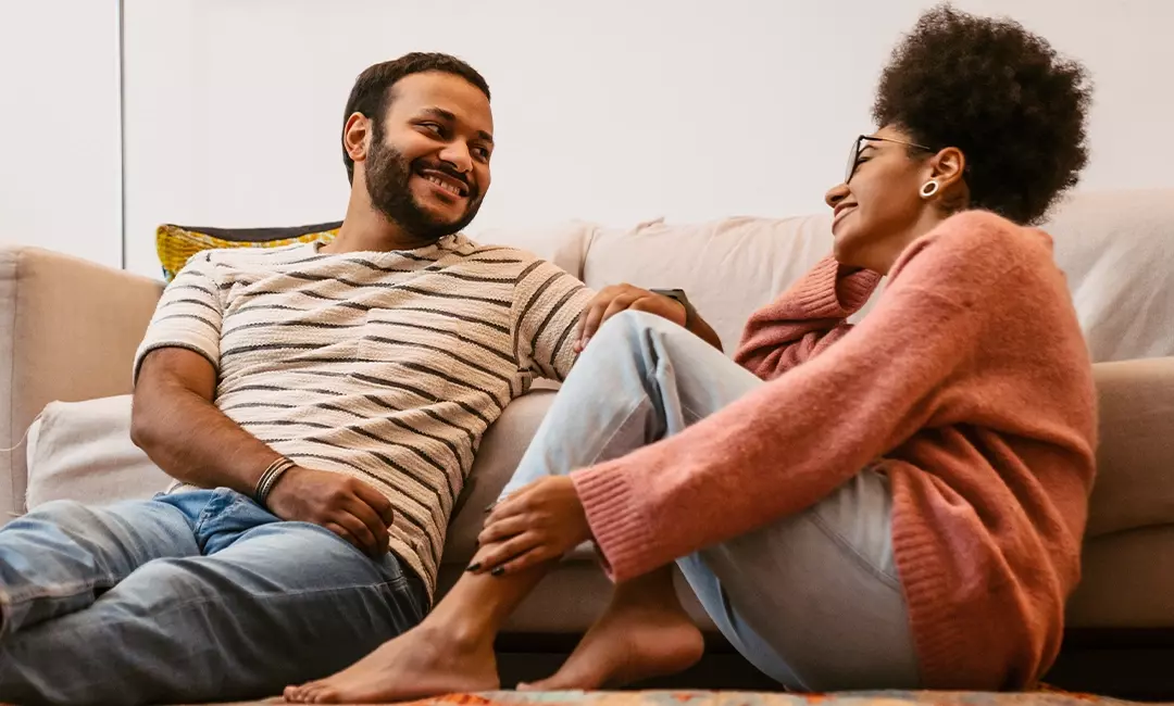 Couple sitting on couch talking after attending couples therapy
