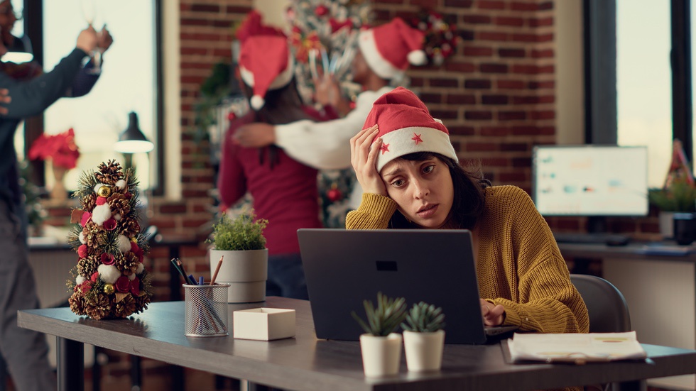 Overcommitted woman at laptop during holiday season