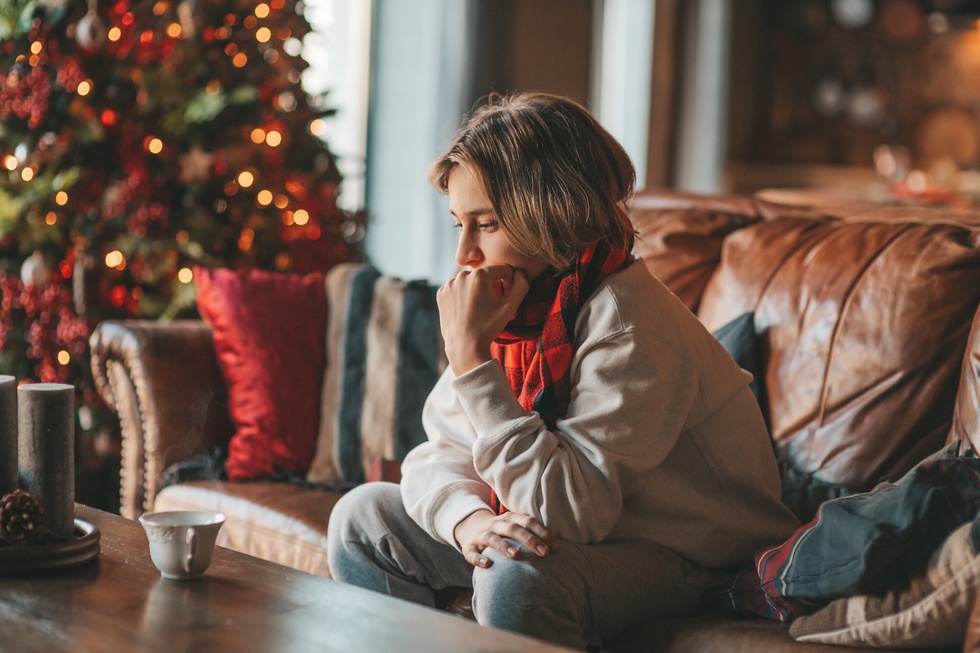 Concerned woman sitting in home during holiday season and experiencing mental health stress