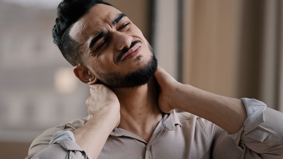 Man experiencing muscle tension in neck as symptom of sex addiction withdrawal
